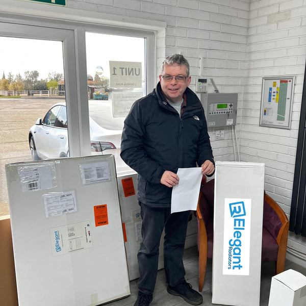 Andy collecting his 1000x300 pre-filled electric towel rail from Elegant Radiators Coventry warehouse, standing next to company van
