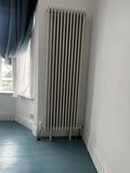 Antico 1800 x 560mm three-column vertical radiator in white, fitted on existing pipe centres