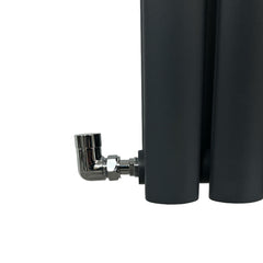 Black cylindrical radiator with a chrome elbow valve on a white background